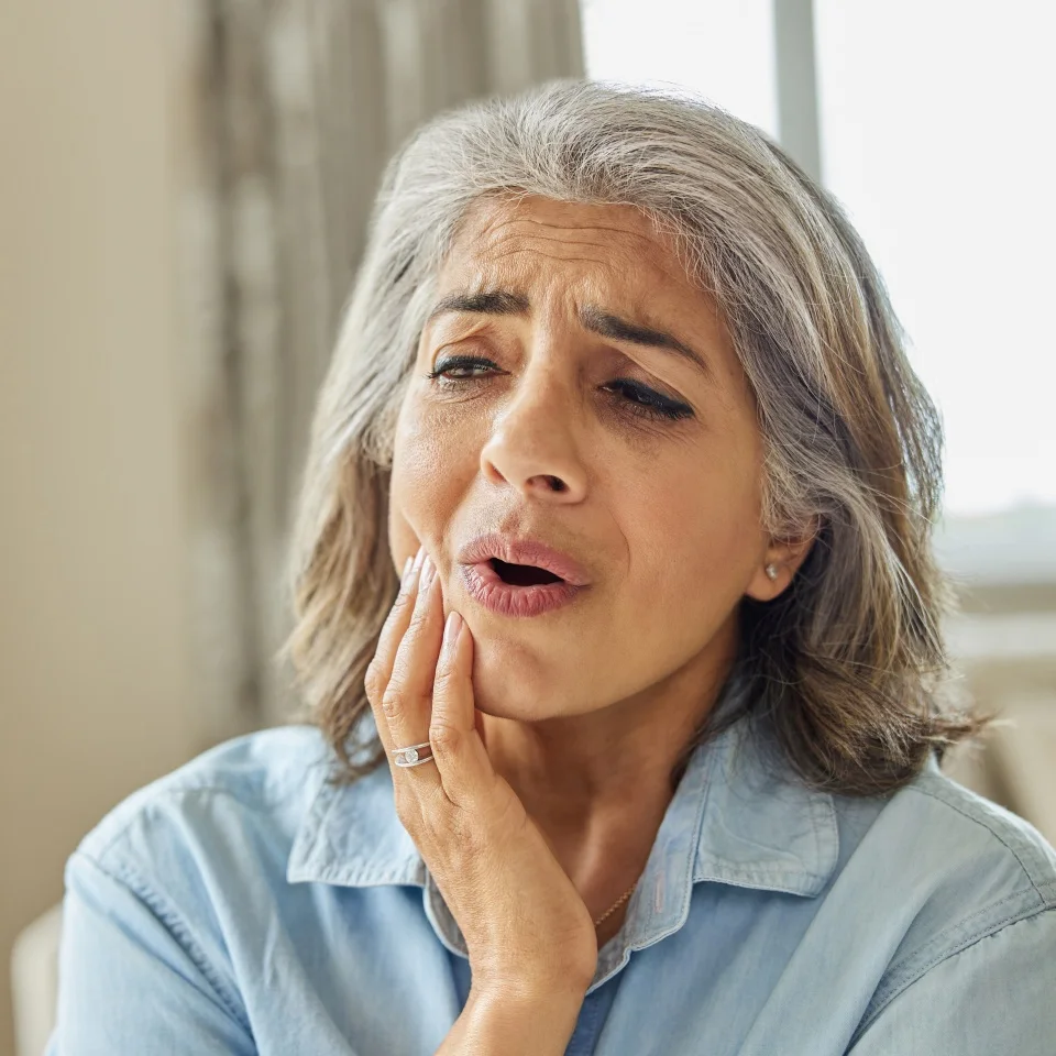 Mature Woman At Home Suffering From Pain With Toothache