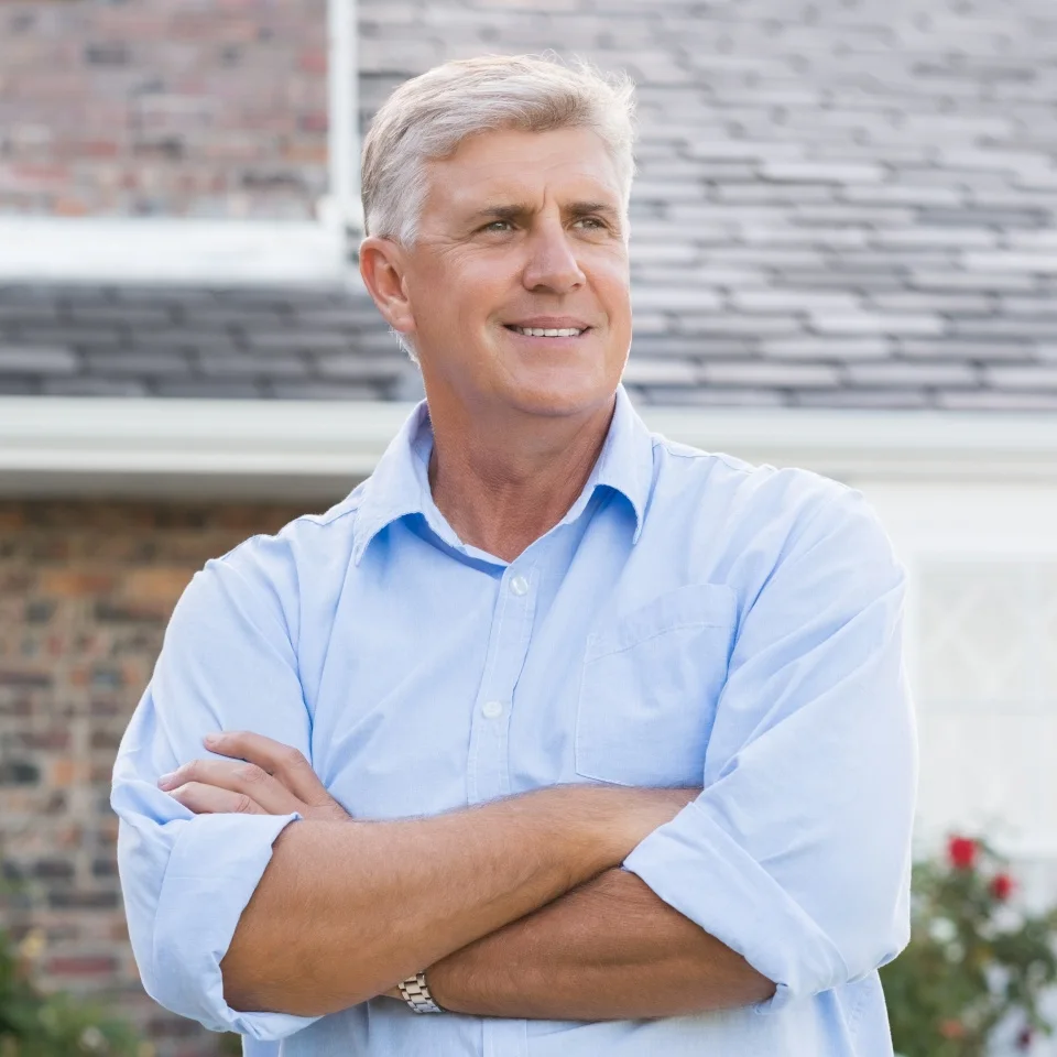 Successful happy retired man standing with crossed arm. Senior man thinking and looking away. Portrait of old man feeling good to retire.