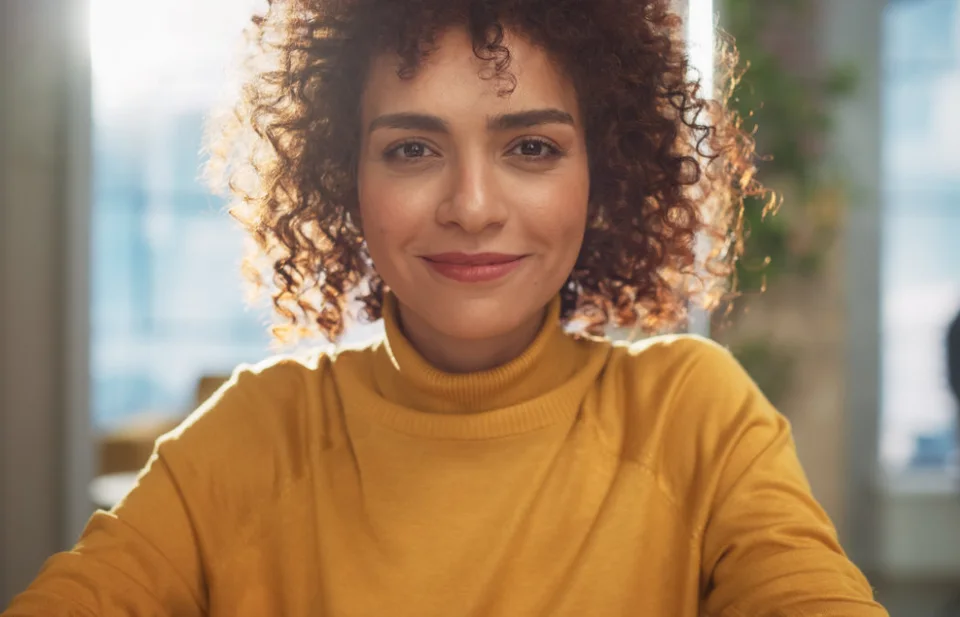 Young Stylish Female with Curly Hair Looking at Camera with Big Smile.